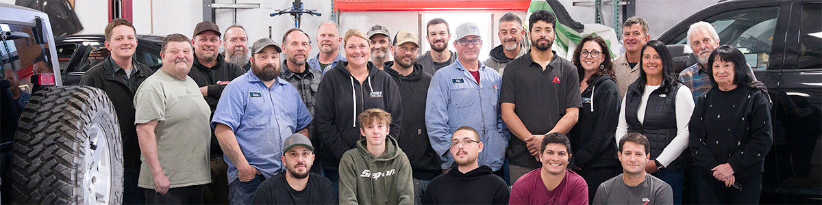 A number of people pose in a group photo.