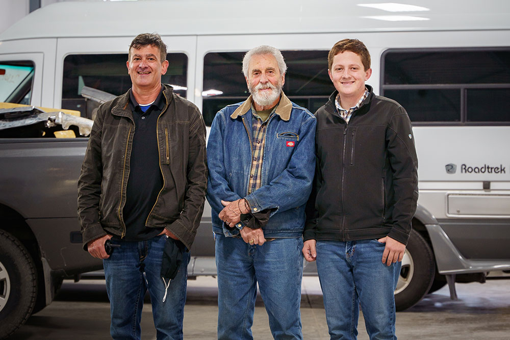 Three smiling men stand next to each other